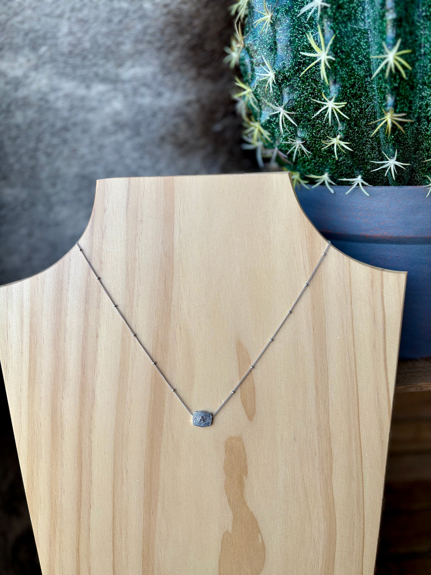Western-inspired silver necklace with beaded chain and mini buckle charm