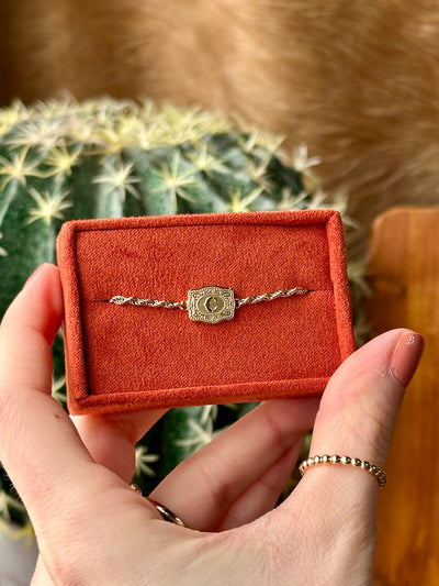 Close-up of gold belt buckle initial charm – dainty Western bracelet design