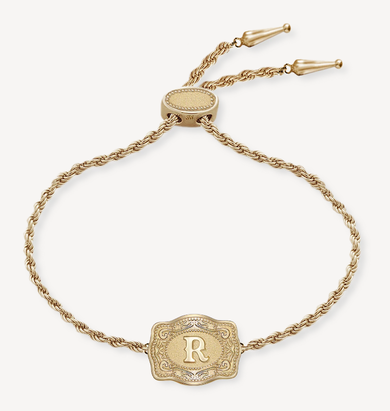 Close-up of gold belt buckle initial charm – dainty Western bracelet design