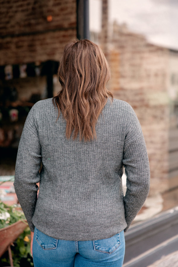 Back view of Take me to church sweater showing versatile cozy sweater paired with jeans for any outing.