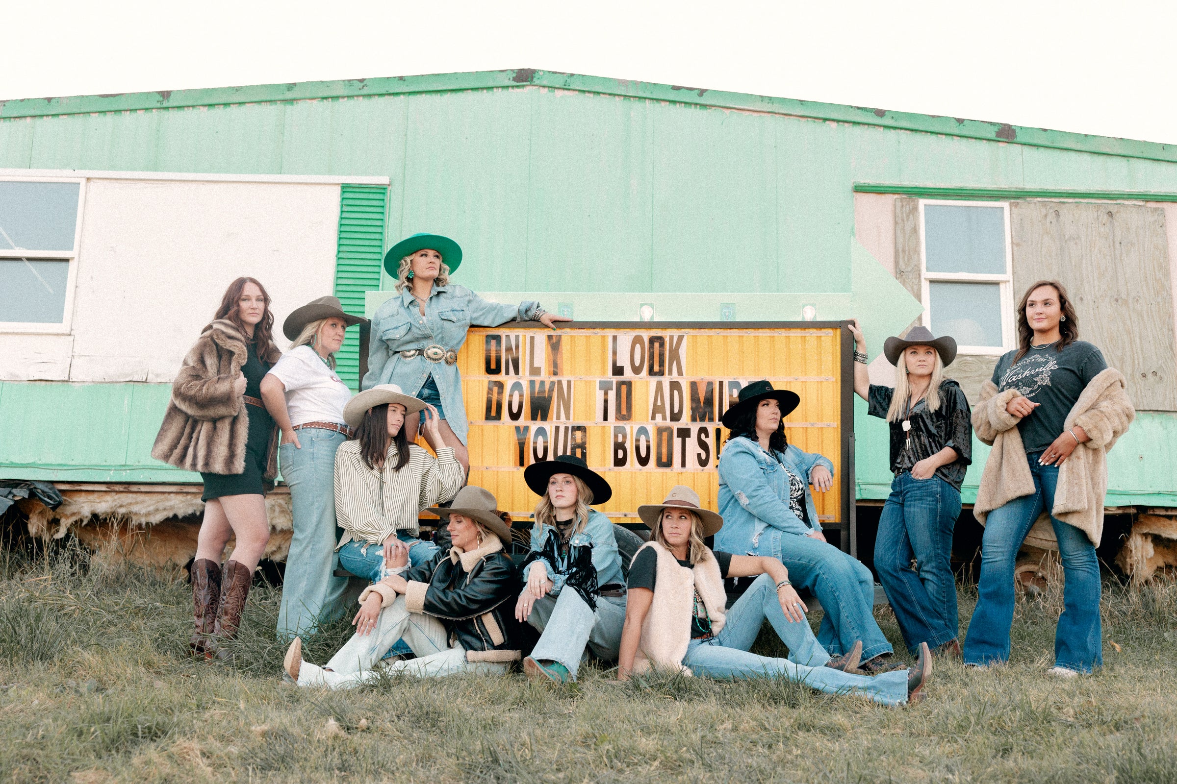 Strong, independent cowgirl women posing in stylish leather boots and Western-inspired outfits, celebrating small-town America heritage.