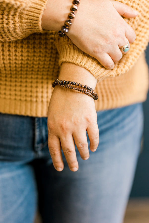 Close-up of the tiered detailing on the Theta Copper Faux Navajo Pearl Adjustable Bracelet modeled by a Broker Leather employee.