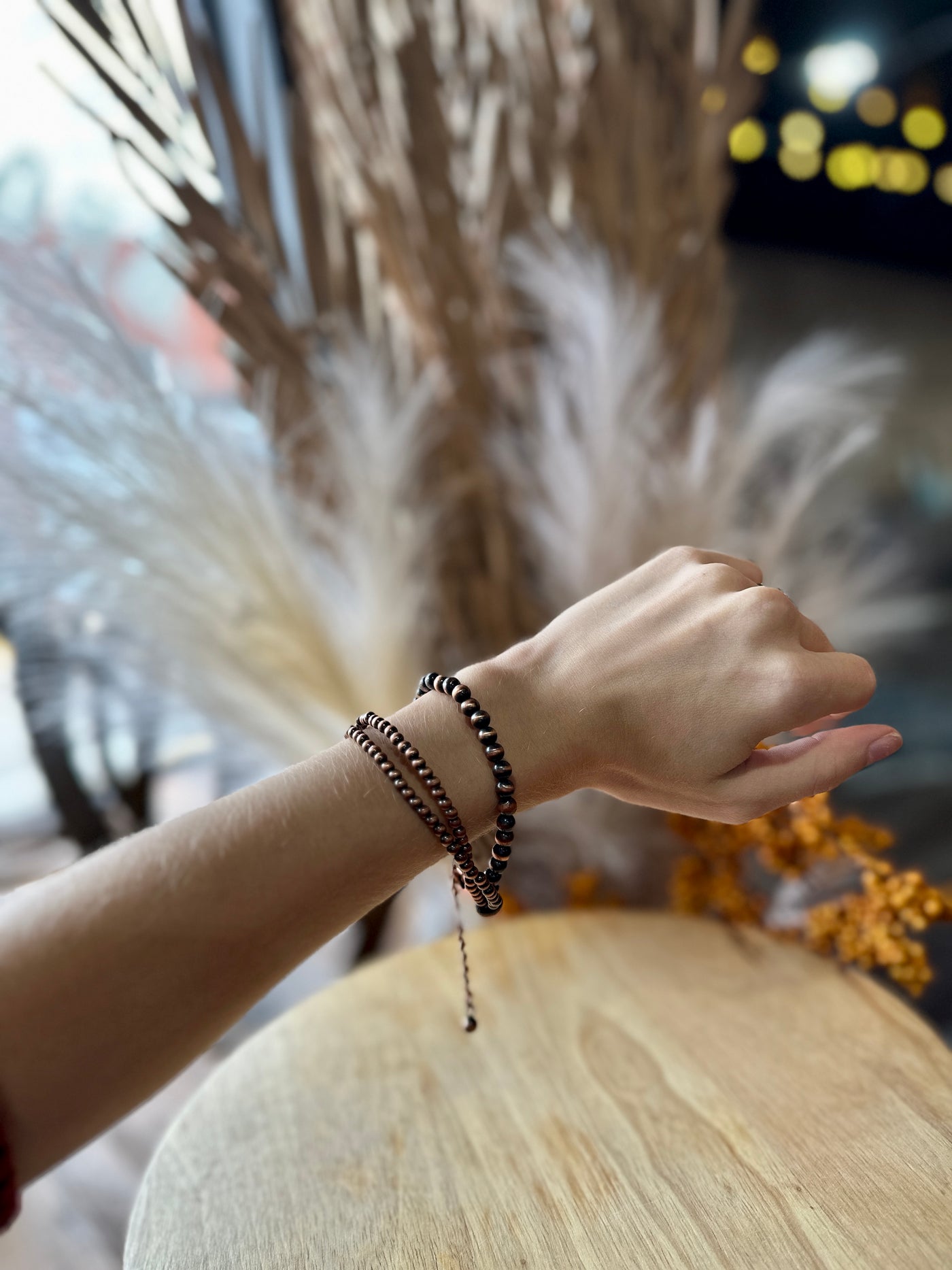 A Broker Leather employee modeling the Theta Copper Faux Navajo Pearl Adjustable Bracelet.