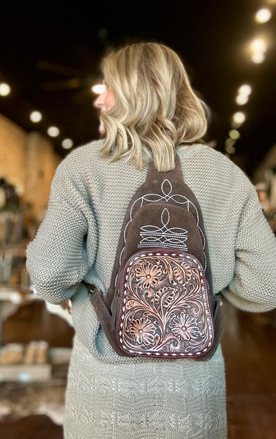 Rich Coffee Brown Suede Backpack with Boot Stitch and Adjustable Straps modeled by boutique staff to show size relevance.