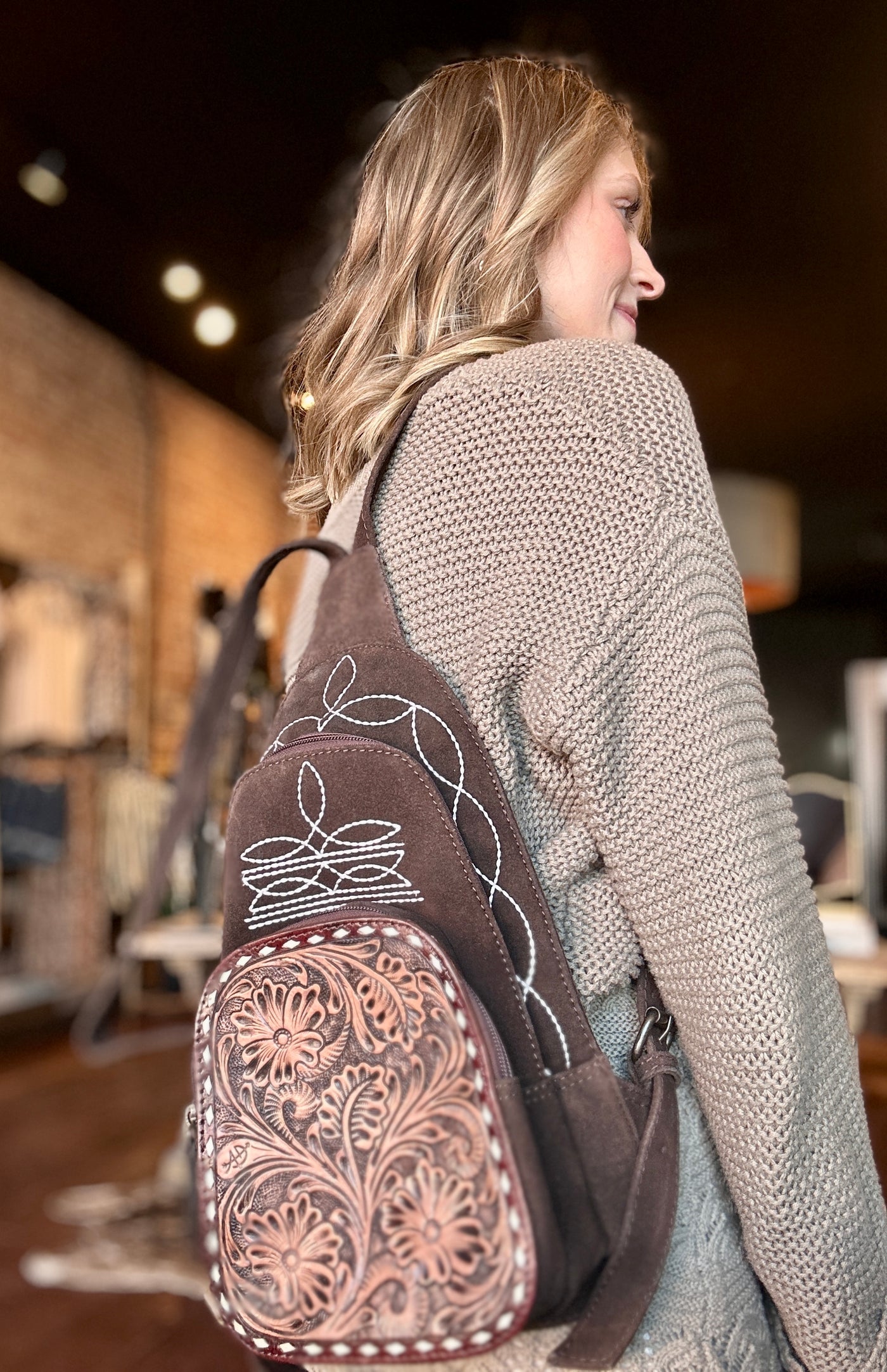 Side View of Treaty Suede Backpack Showing Spacious Storage Compartments.