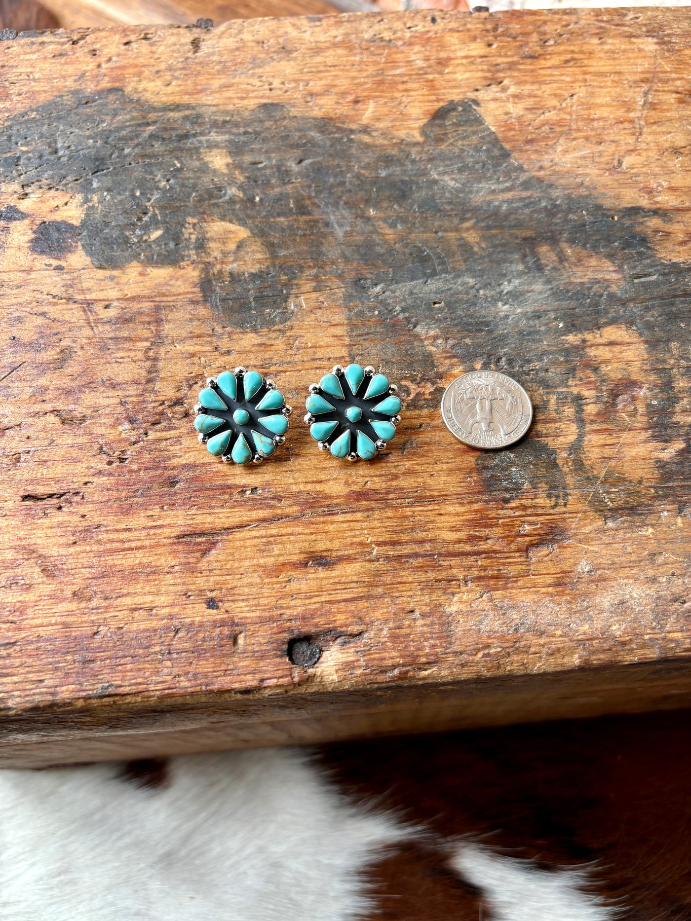 View of the turquoise earrings next to a quarter highlighting their 1-inch diameter and cluster design.