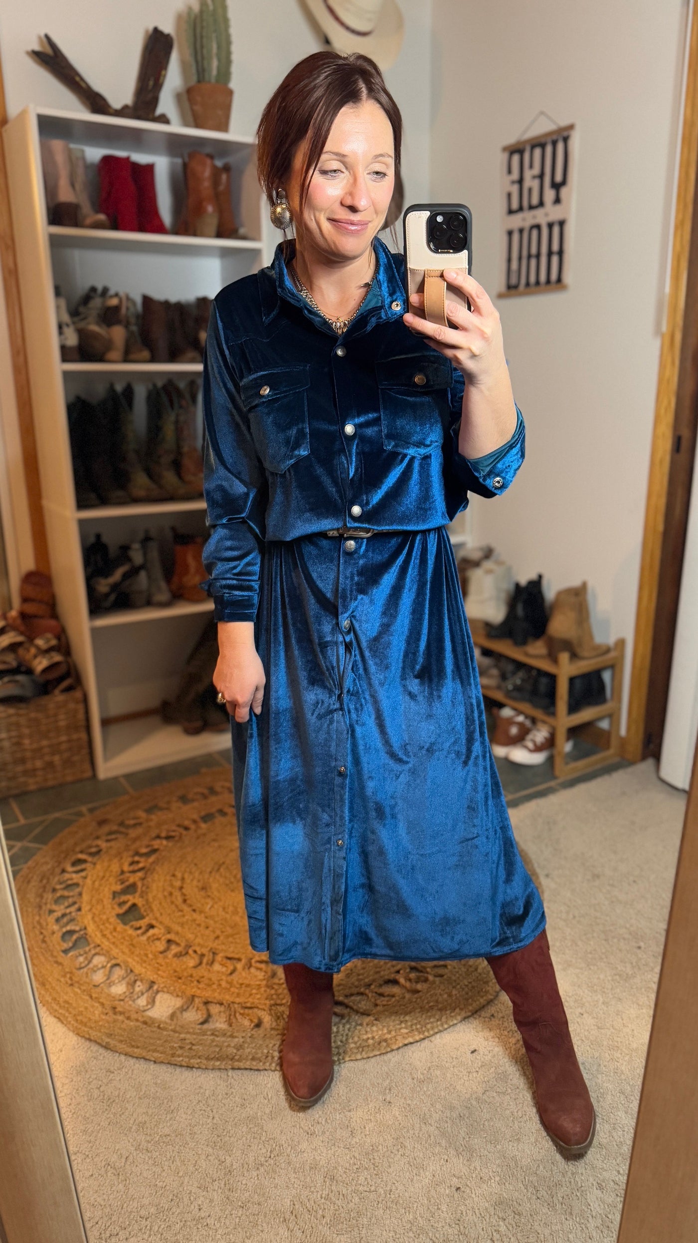 Model showcasing the Zion Teal Velvet Shirt Dress in a natural home setting, reflecting its inspiration as a great selection for a Midwest winter wedding.