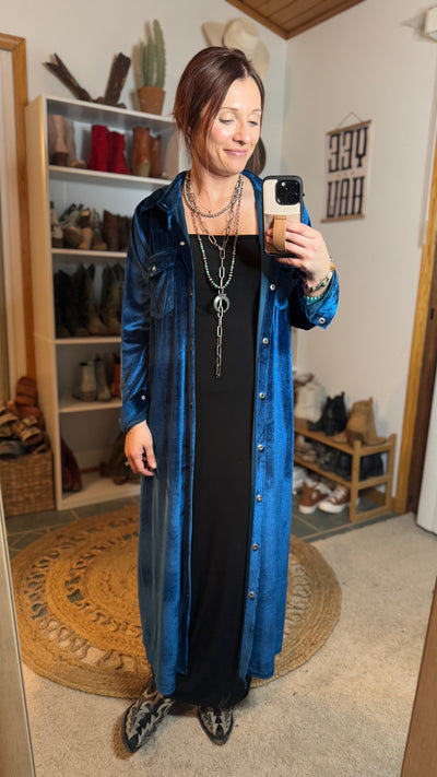 Fashion-forward Zion Teal Velvet Shirt Dress paired with a basic black dress and boots, ready for an autumn adventure or a stylish city day out.