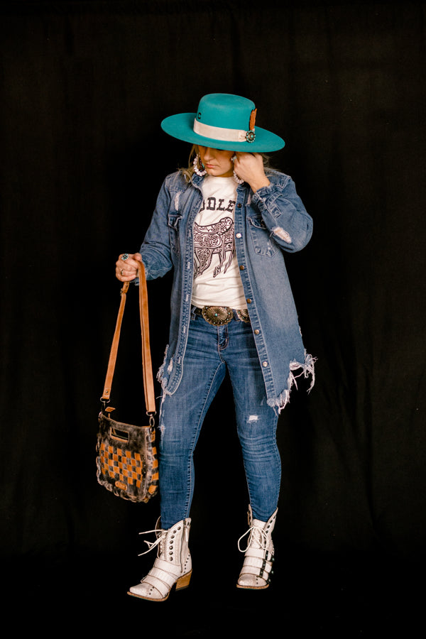 Brianne Huiskamp, the owner of Broker Leather, modeling the Lane Showdown Buckled Boots in white.