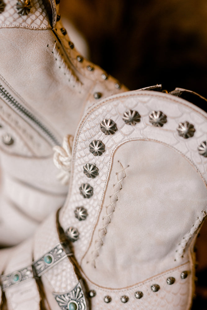 Close-up of many intricate details of the Lane Showdown Buckled Boots in ceramic crackle white.