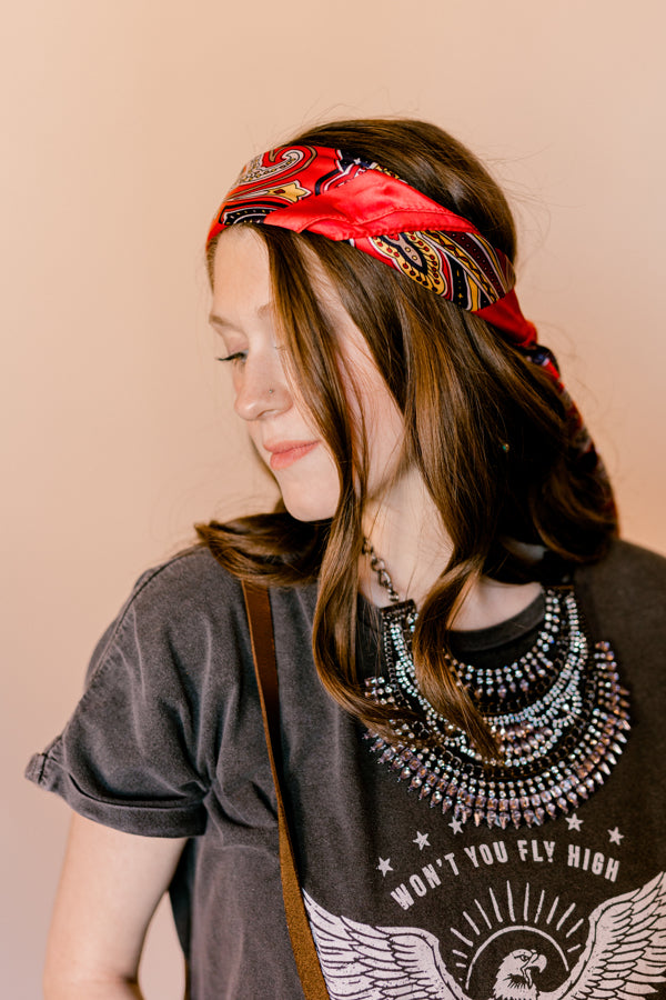 Side view of a woman wearing the Welsh Red Paisley Wild Rag as a headband.